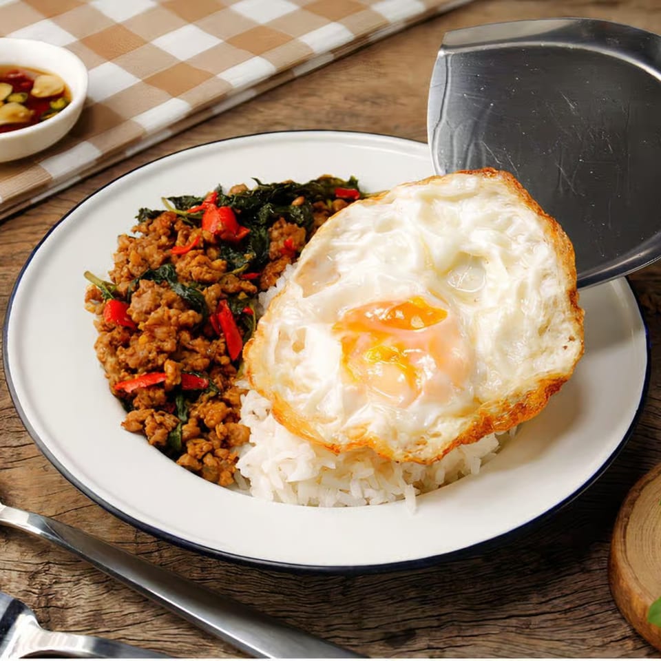 Crystal Garden's Asian-fusion dish: stir-fried minced meat with basil, rice, and a fried egg.